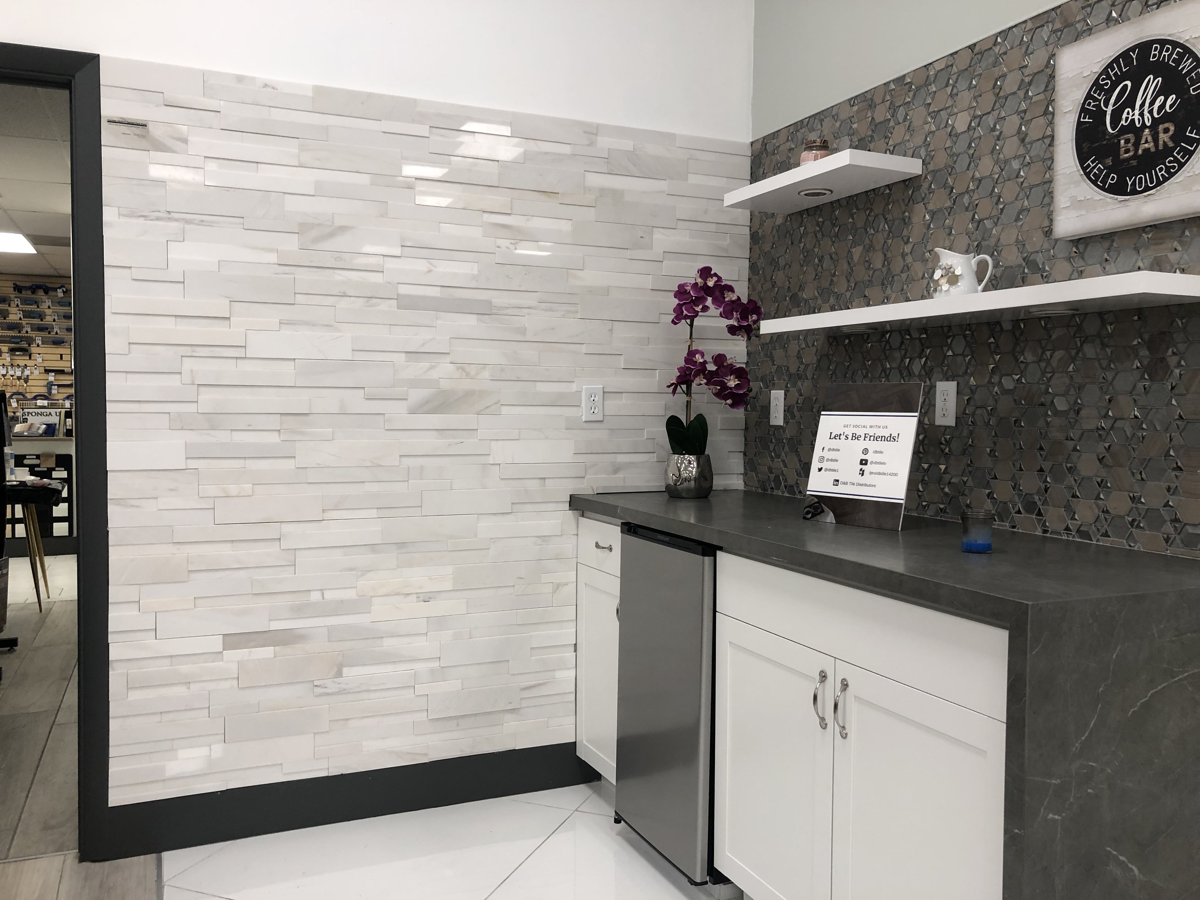 Norstone White Marble Aksent 3D on tile showroom feature wall with modern styled kitchen vignette in white and grey color scheme